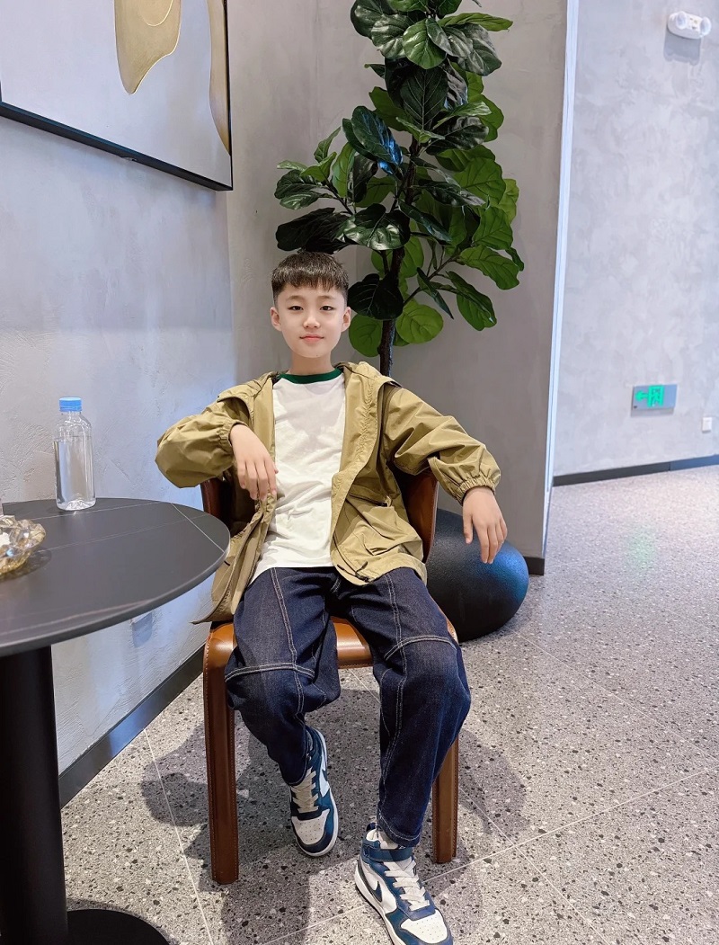 Cậu bé 10 tuổi mặc đồ lịch sự, nhìn camera đáng yêu