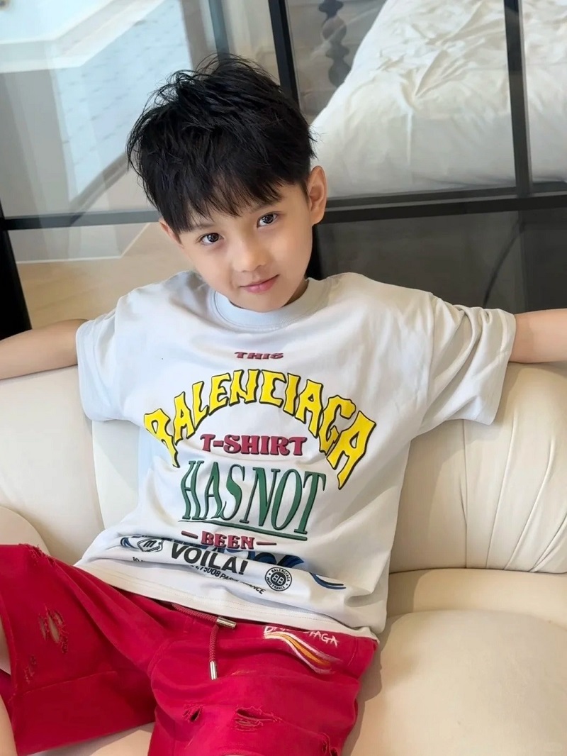 Cậu bé 10 tuổi giơ tay chào với nụ cười tươi