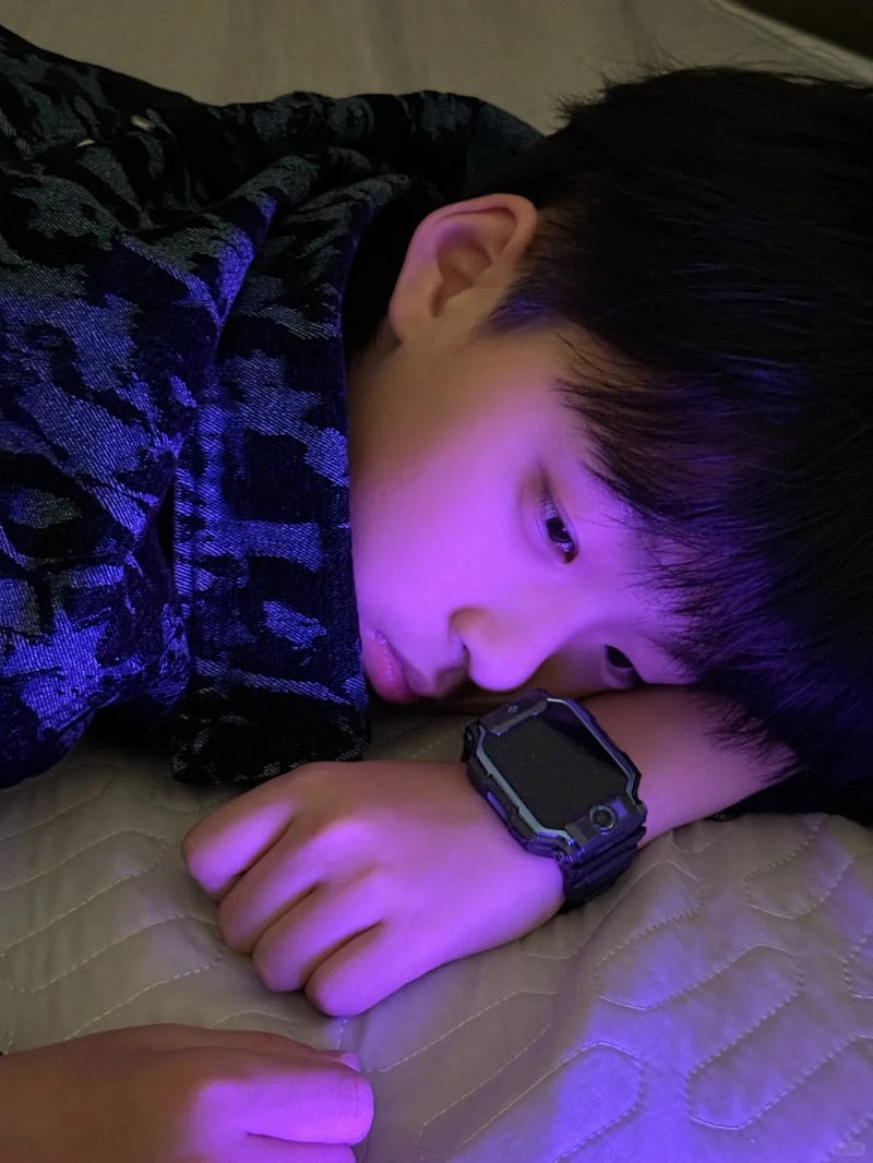 Bé trai 10 tuổi nằm chơi trong ánh đèn mờ dịu