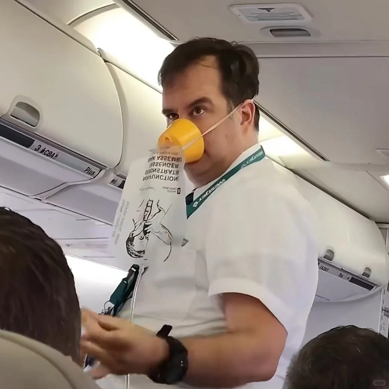 Nhân viên trên máy bay thở oxy, biểu cảm kiểu “bay cao quá thiếu không khí”.